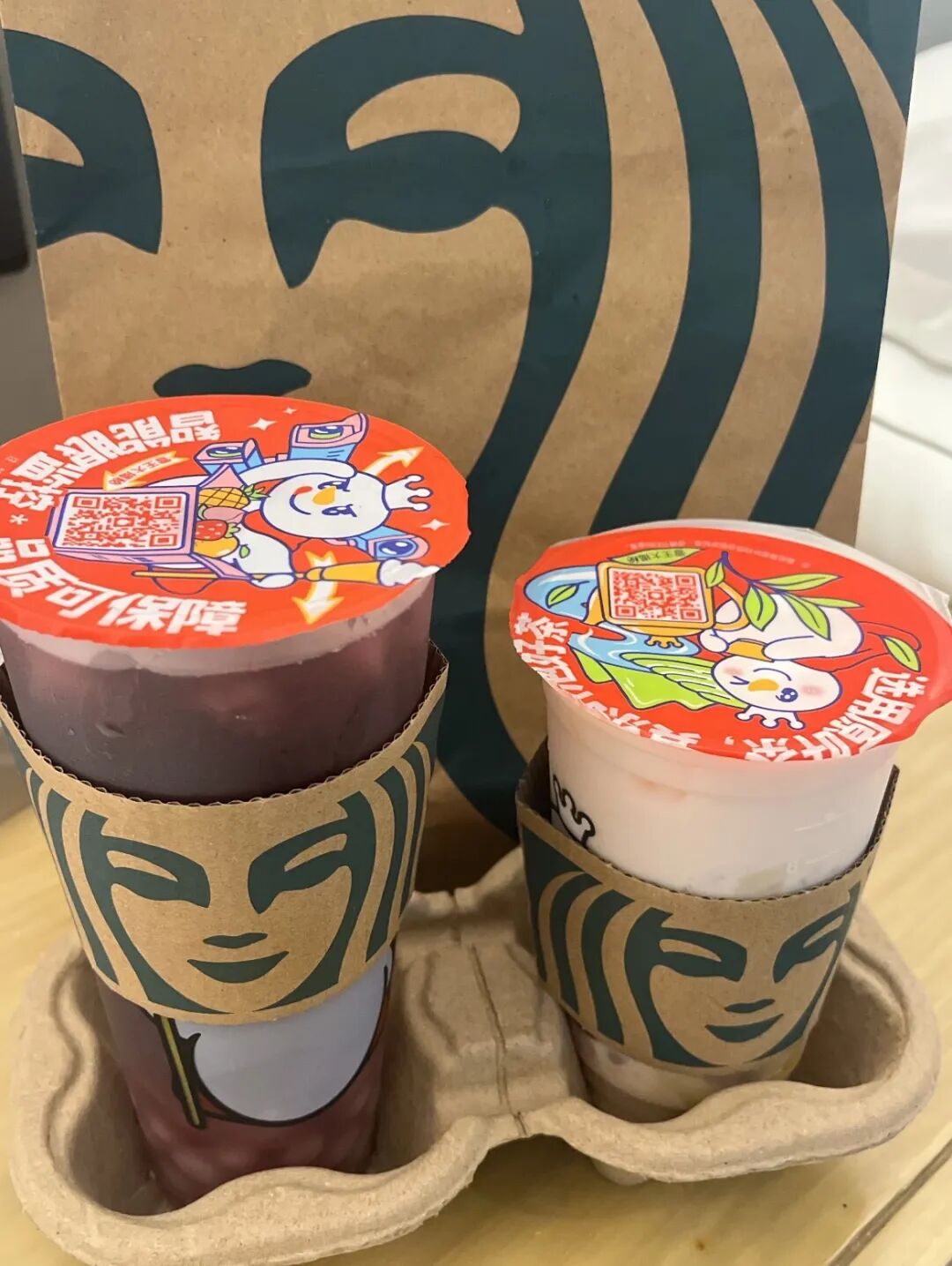 星巴克纸袋与杯套搭配雪王卡通封口膜的两杯饮品